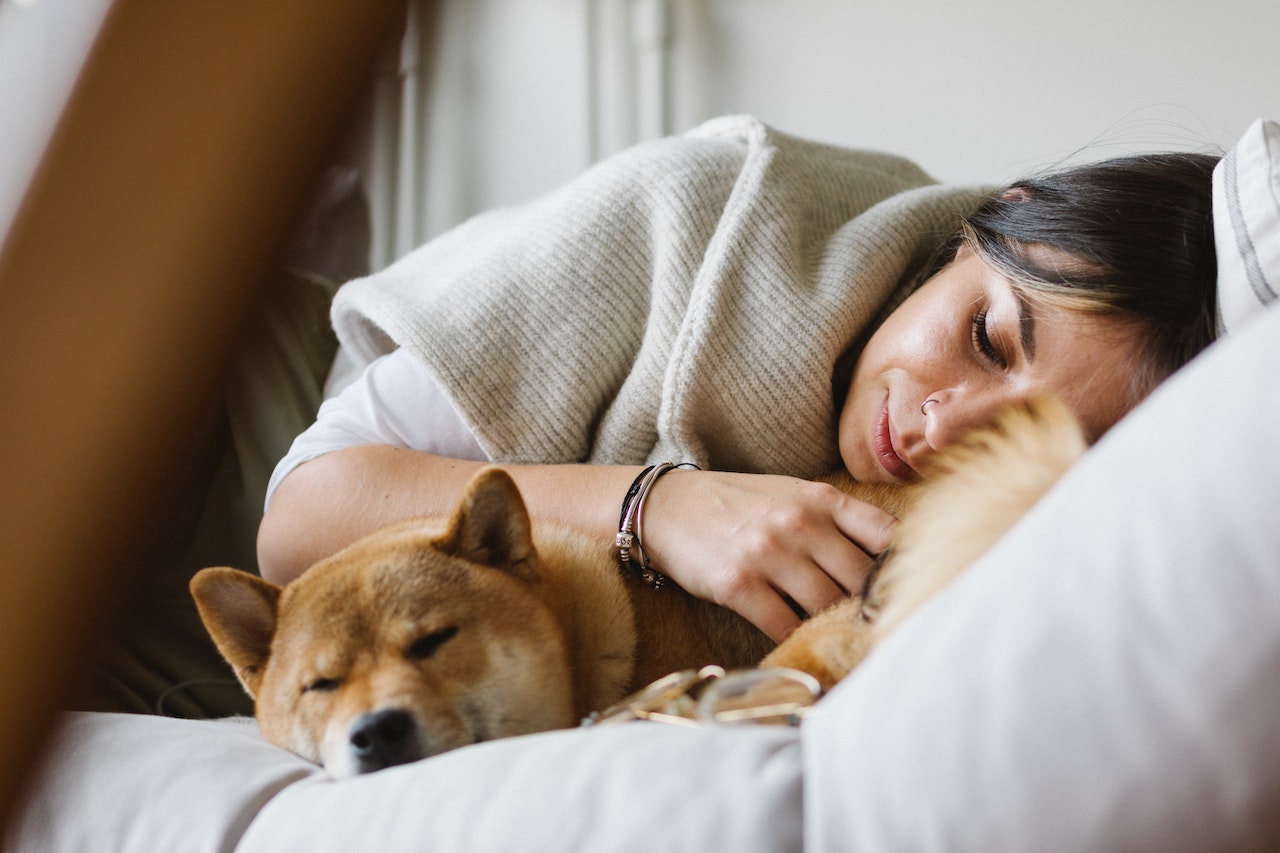 une femme et son chien dorment ensemble