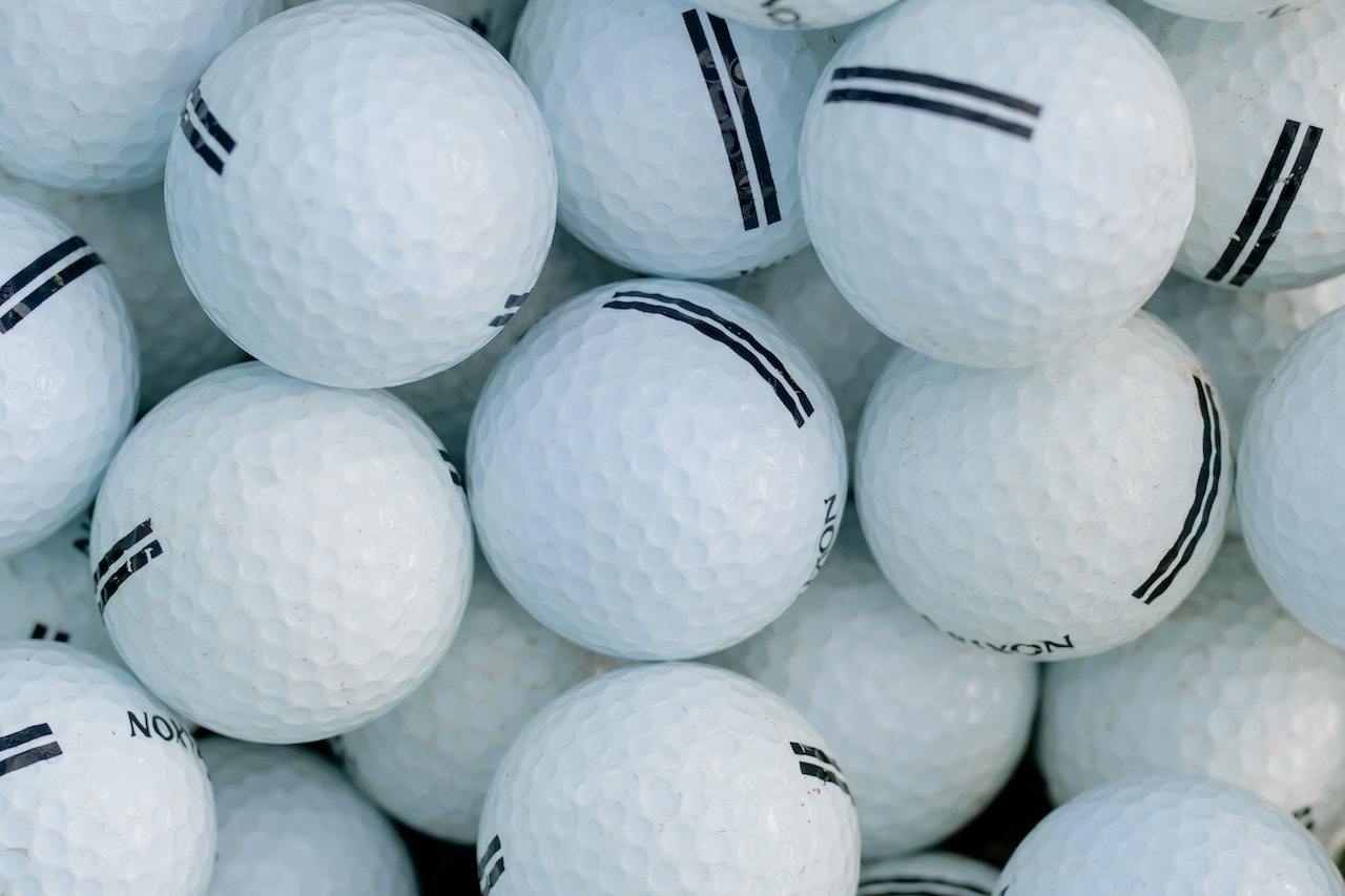 Lot de balles de golf dans un sceau de practice
